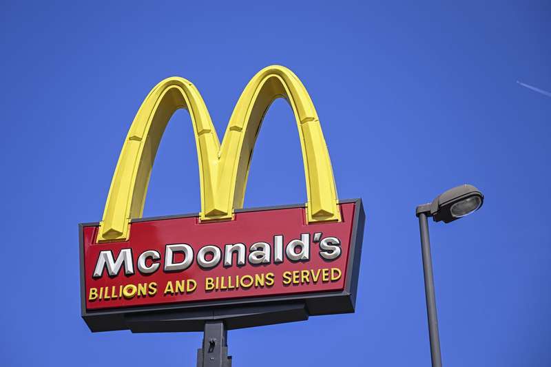 A McDonald’s sign that reads “McDonald’s, billions and billions served,” seen against a blue sky.
